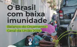 Pessoas em situação de rua dormindo na calçada ao lado de carros estacionados, ilustrando a precariedade social no Brasil.