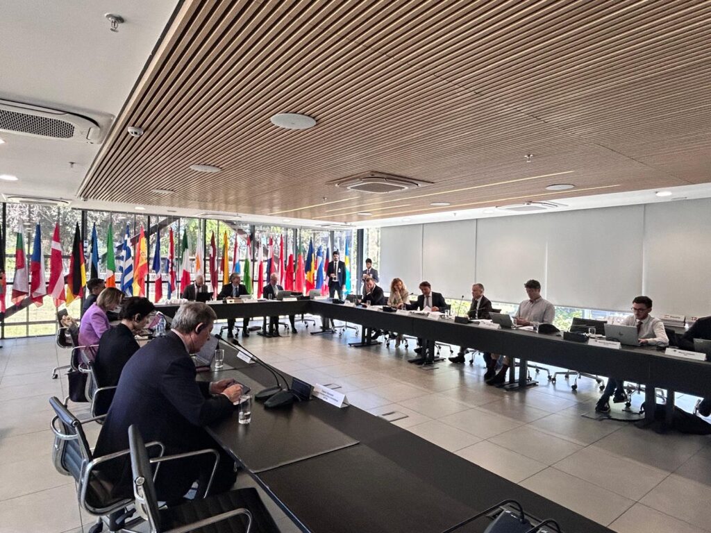 Foto mostra sala de reunião, com mesa oval onde várias pessoas estão sentadas e reunidas para falar sobre governança tributária global